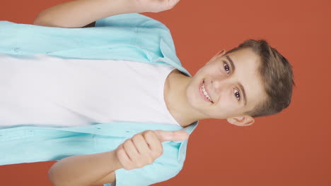 Vertical-video-of-The-boy-promoting-is-pointing-to-the-side-and-laughing.